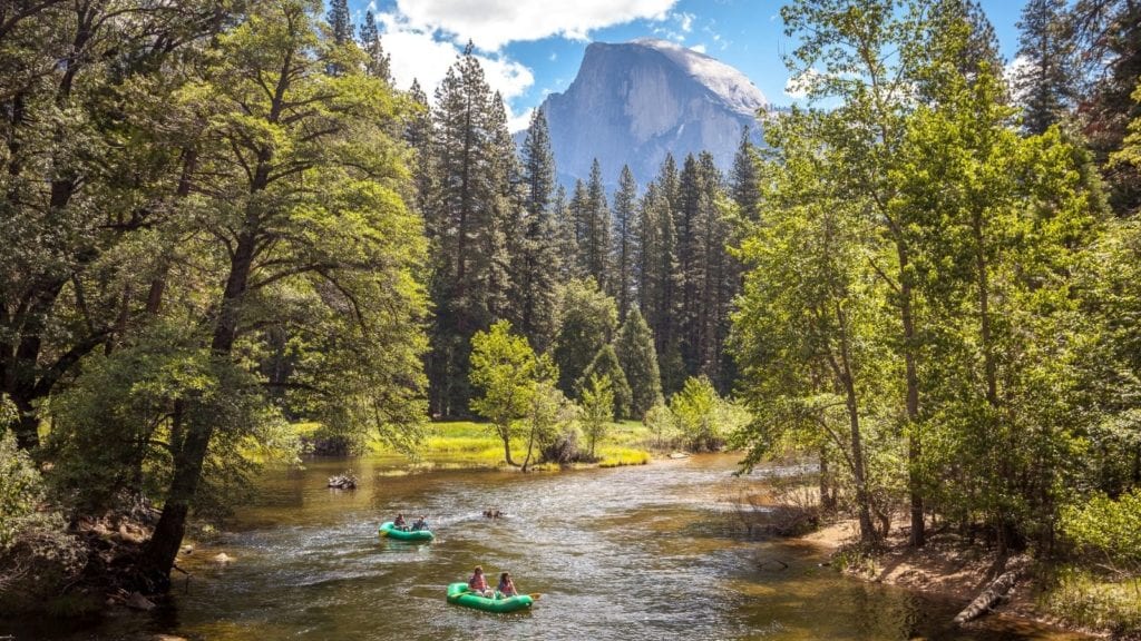 Yosemite Valley with rafters and Half Dome in background. The Yosemite Valley is a 40 minute drive from Rush Creek Lodge