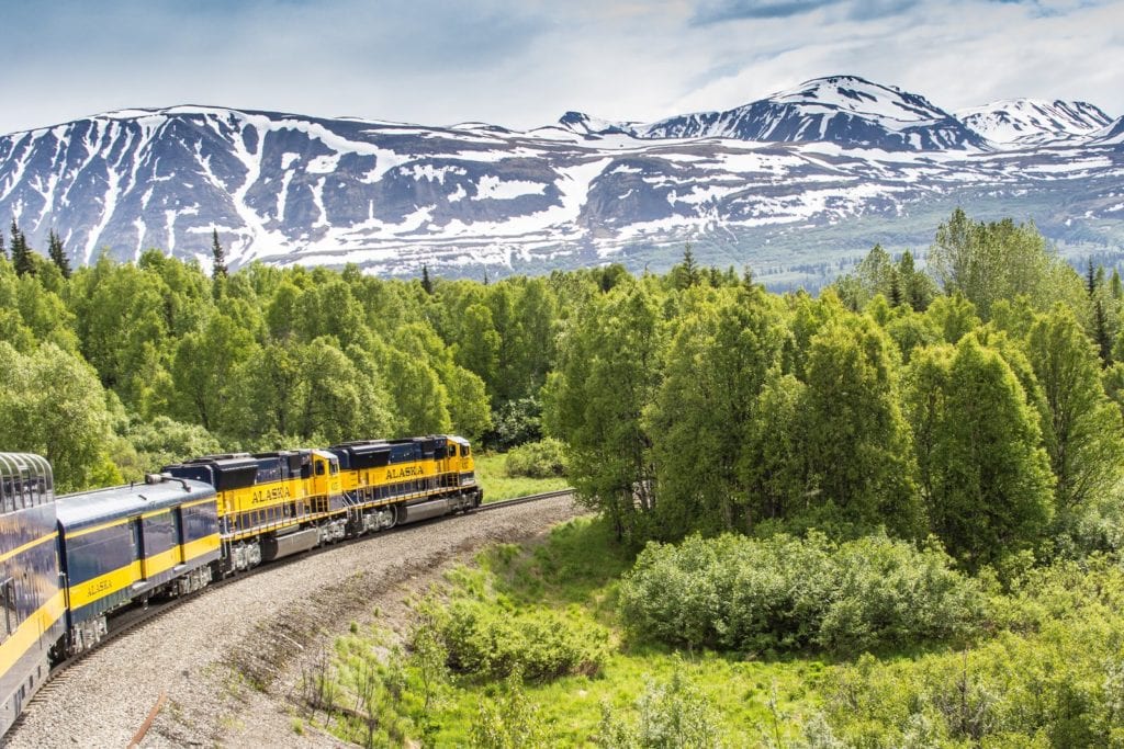 Alaska Railroad train with mountains in background of scenic train trip