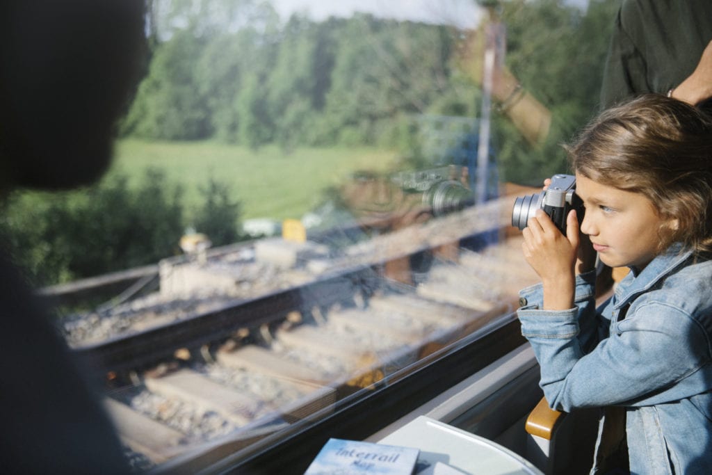 Young child looking out window of a scenic train in Europe