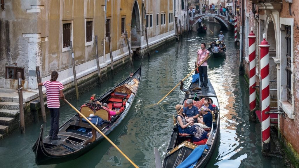 gondolas passing each other in a canal in Venice. Venice is one of the top Europe tourist attractions