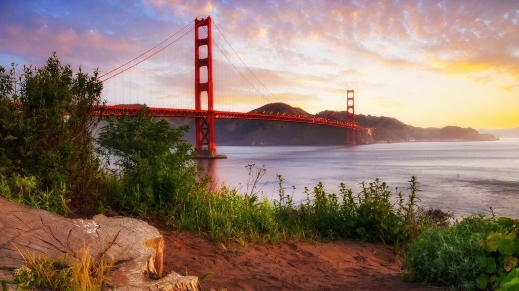 Golden Gate Bridge at sunrise. The Golden Gate bridge and nearby national parks are among the top tourist attractions in the U.S.