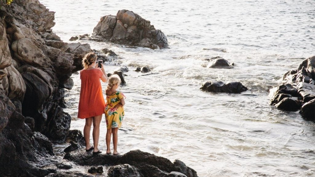 Mother and daughter climbing rocks on the beach in Maui, Hawaii (Photo: @debb_alba via Twenty20)