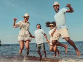 family jumping in the sand at the beach