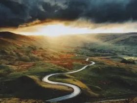 a windy road for a road trip with a moody sky