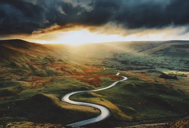 a windy road for a road trip with a moody sky
