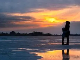 woman and child on cold beach at sunset
