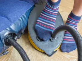 A woman with air foot pump pumps an inflatable mattress. (Photo: Yevhen Prozhyrko/Shutterstock)