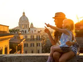 Mother and girl sitting on street overlooking rooftops of Rome (Photo: Shuttertock)