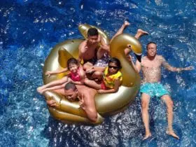 family floating in swimming pool relaxing