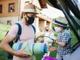 masked family packing a car to travel after the pandemic