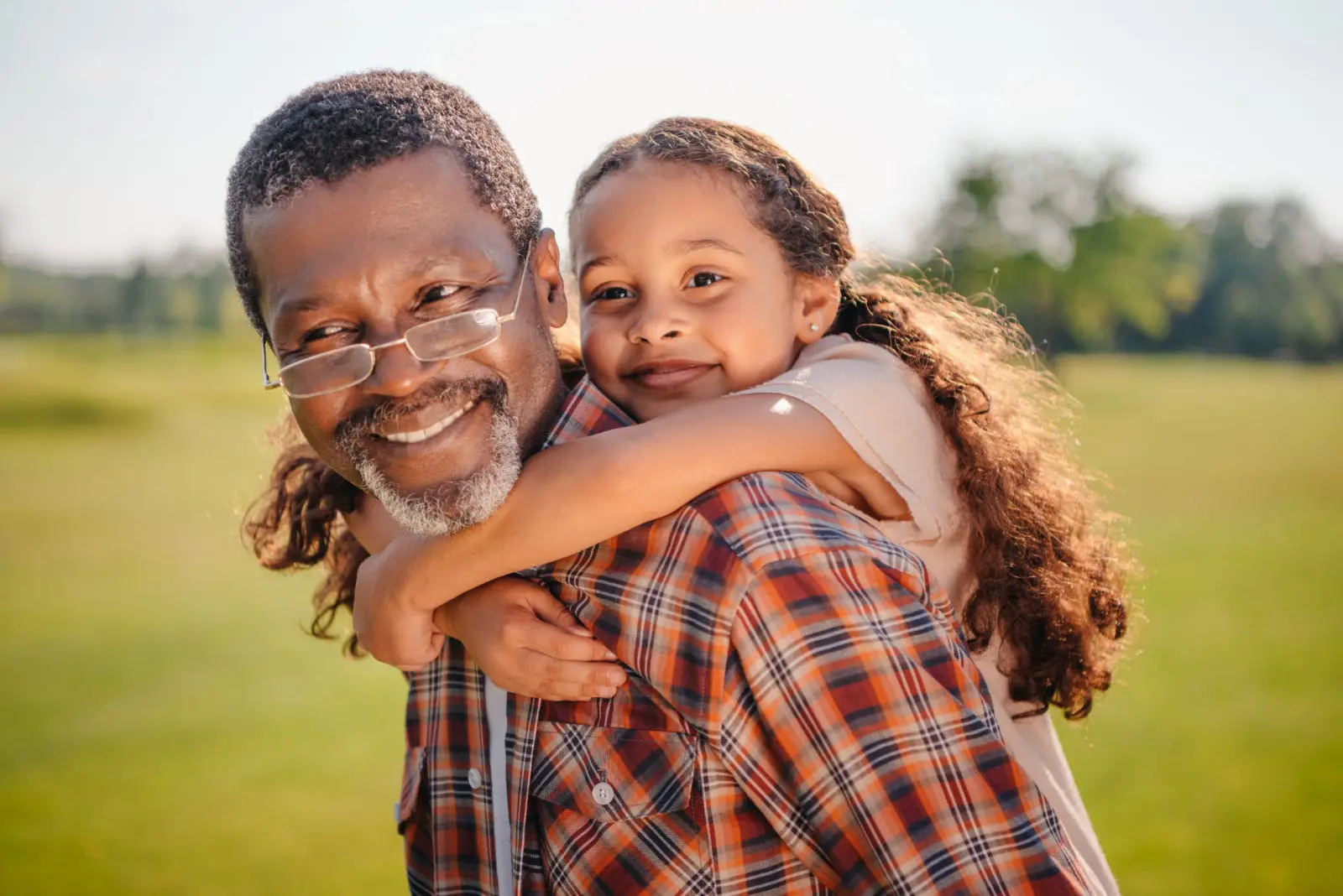 Happy grandfather giving a piggyback ride to his grandchild