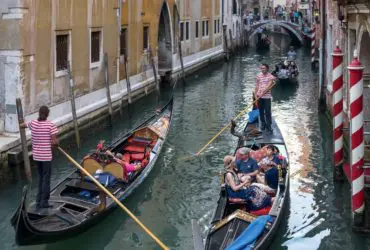 Gondolas passing each other in a canal in Venice. Venice is one of the top Europe tourist attractions