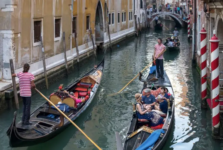 Gondolas passing each other in a canal in Venice. Venice is one of the top Europe tourist attractions