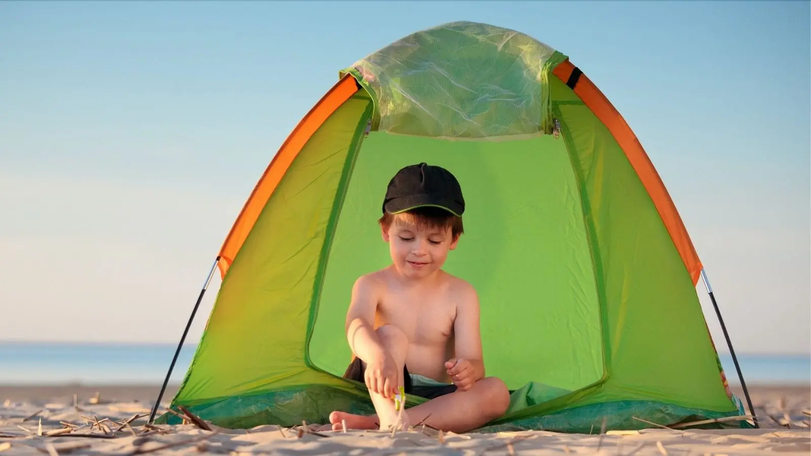 Little boy playing near a beach tent (Photo: Levranii / Shutterstock)