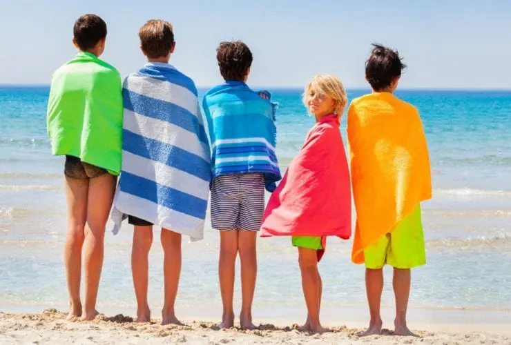 Kids drying off with beach towels after swimming (Photo: Sergey Novikov / Shutterstock)