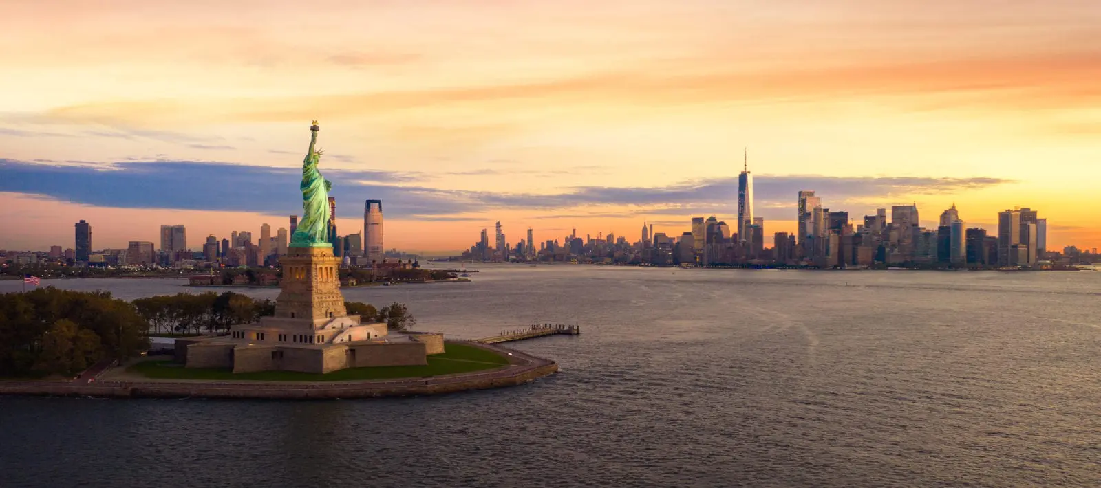 beautiful sky and New York City in background with Statue of Liberty in foreground