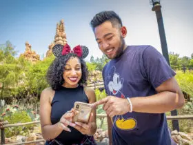 Two people at Disneyland looking at their phones