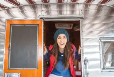 Woman poking her head out of a vintage RV (Photo: @jordvdz via Twenty20)