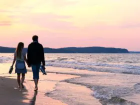 Beach couple holding hands at sunset (Photo: @TatianaMara via Twenty20
