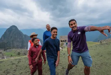 Adventures by Disney adventure guide showing a family the sights of Machu Picchu