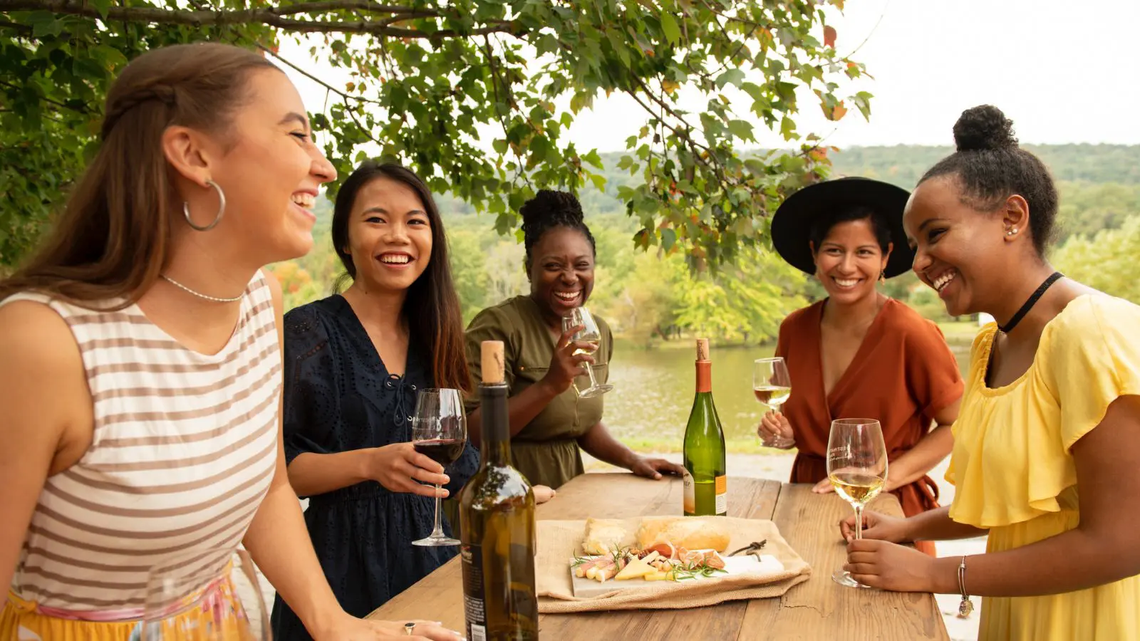 Girlfriends enjoy wine and snacks at a picnic table at Doukenie Winery (Photo: Todd Wright / Visit Loudoun)