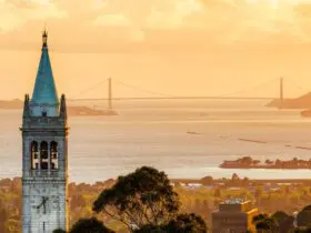 Sather Tower at UC Berkeley campus, with Berkeley and the Golden Gate Bridge in the background.