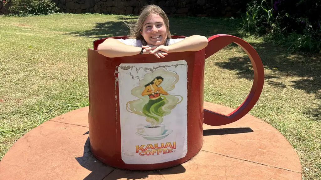 A teenage girl in an oversized coffee cup on the Kauai Coffee Estate