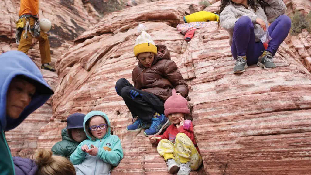 Kids in Patagonia hats and jackets playing on a rock formation