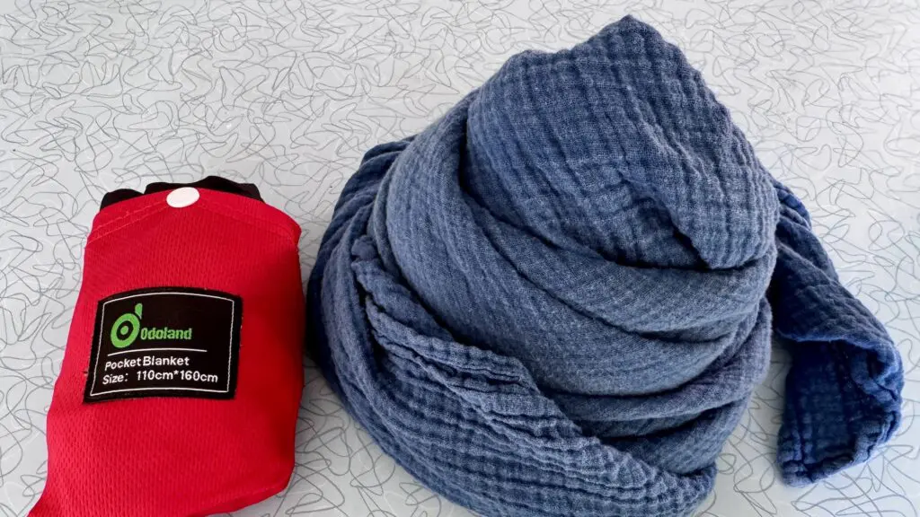 two types of blankets good for airplanes: a small foldable travel blanket and a blue scarf