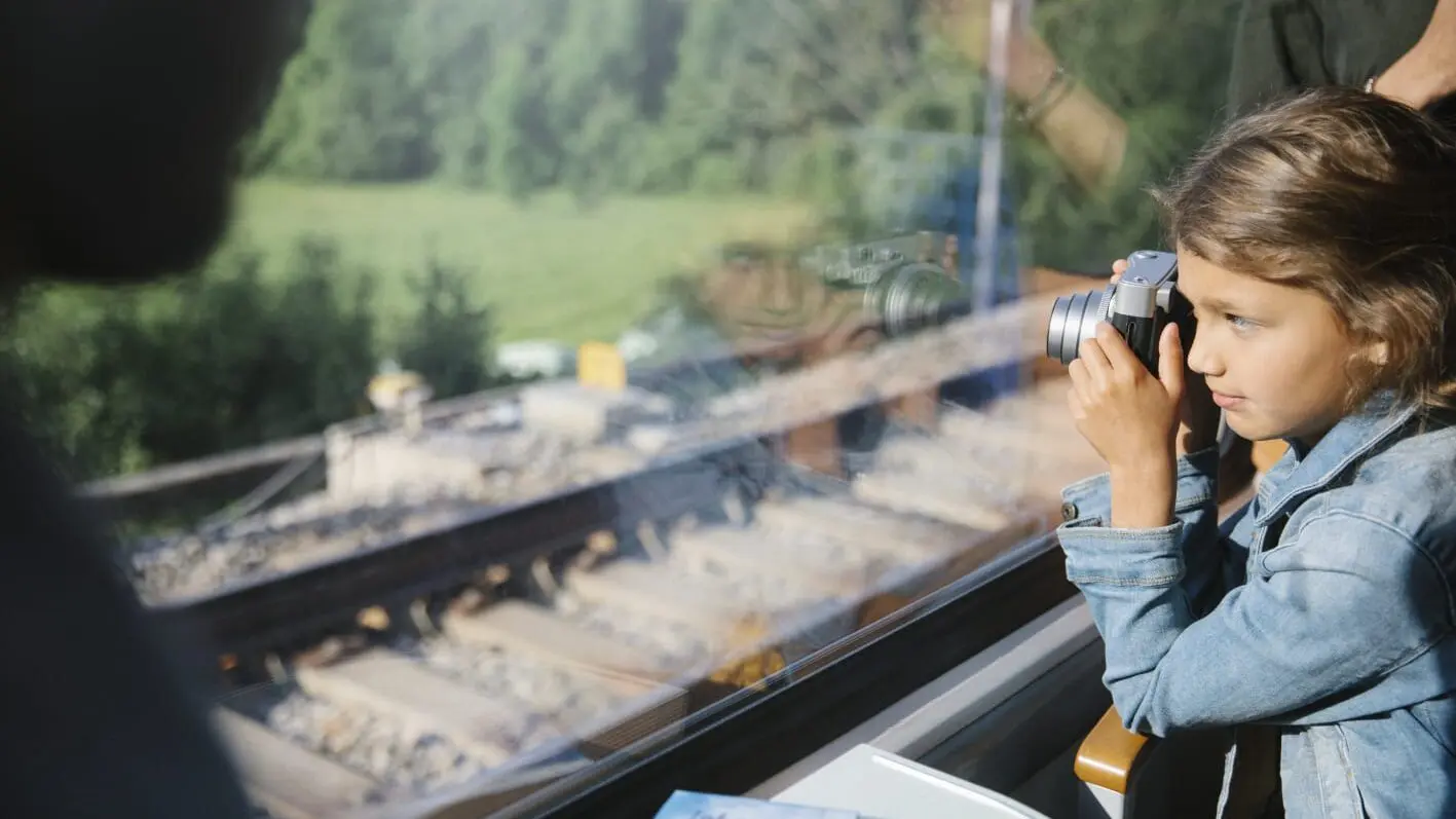 Young child looking out window of a scenic train in Europe