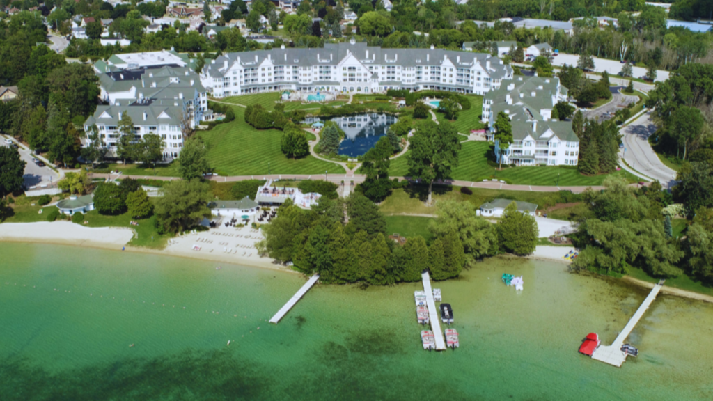 An aerial view of the lake and the white buildings of the resort at The Osthoff Resort