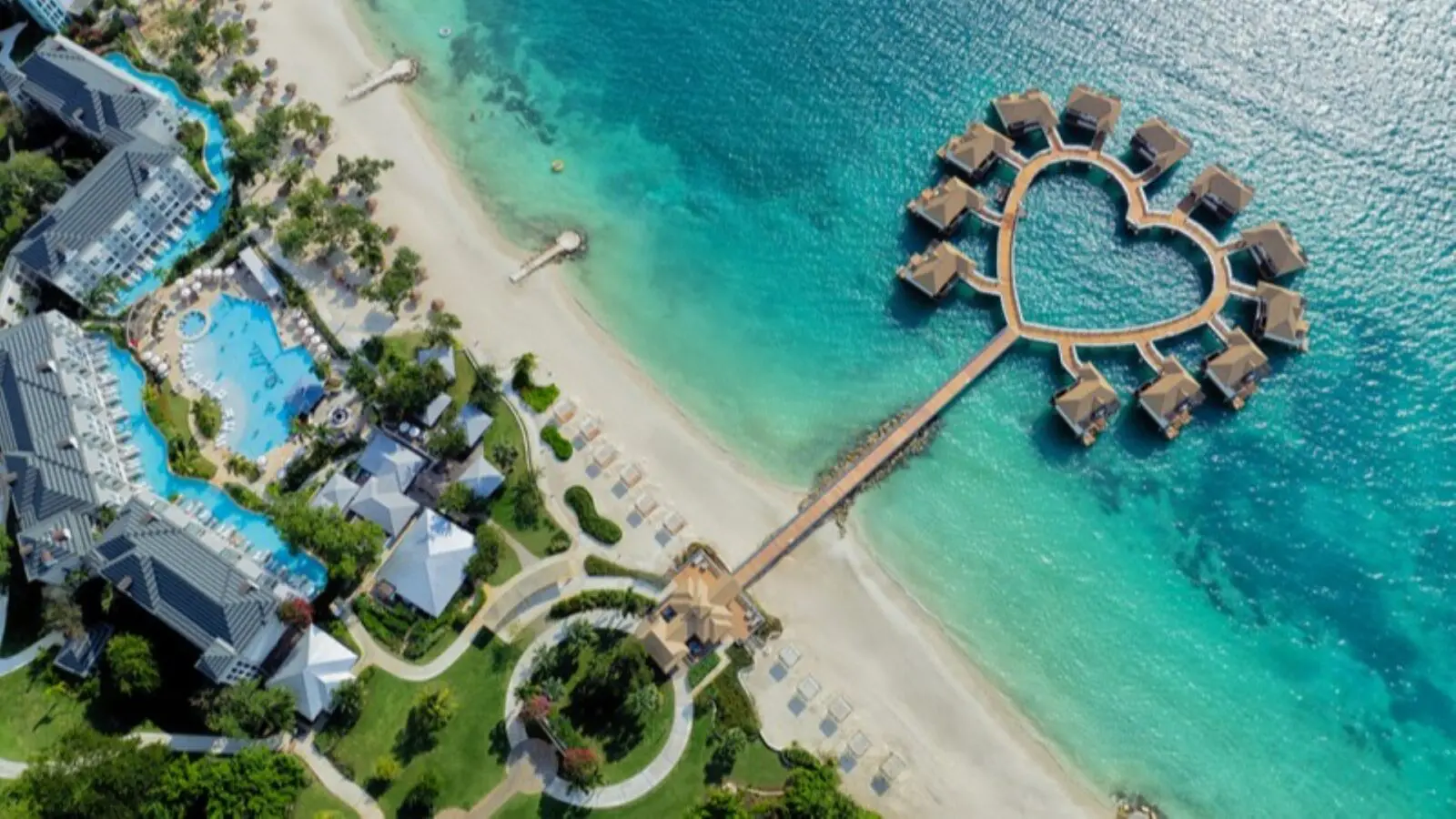 A drone view of the overwater bungalows and heart-shaped deck at Sandals South Coast