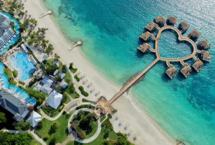 A drone view of the overwater bungalows and heart-shaped deck at Sandals South Coast