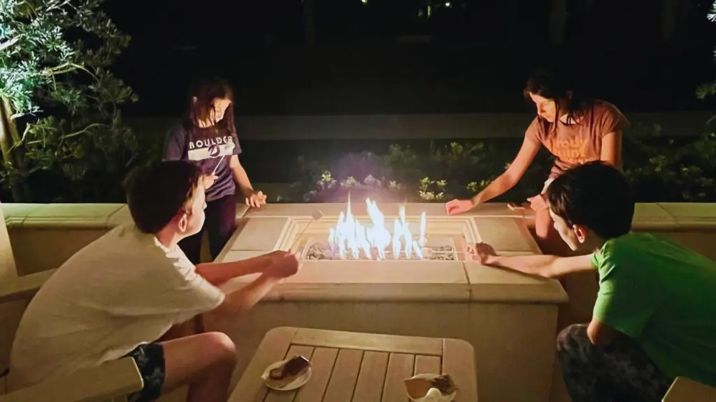 Kids roasting marshmallows for s'mores at a private fire pit at the Waldorf Astoria Monarch Beach in Dana Point California