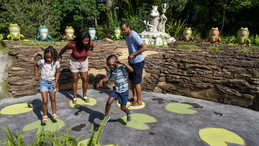 Family jumping on musical green lily pads inside DreamWorks Land at Universal Orlando Resort.