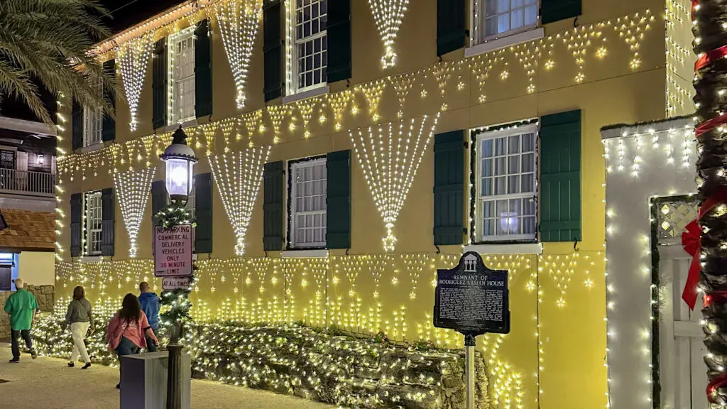 A yellow historic building covered in white lights during St. Augustine's Nights of Lights event