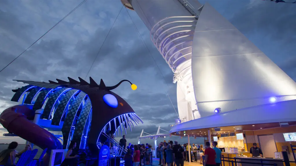 Glowing slide themed after a sea monster, on top of a cruise ship at dusk