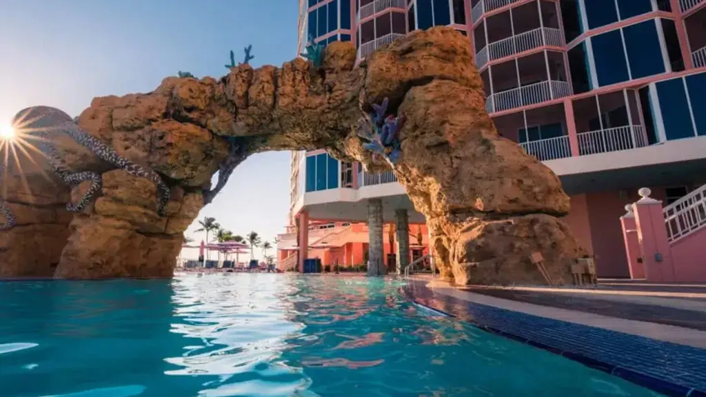 Swimming pool with natural rock formation at sunset