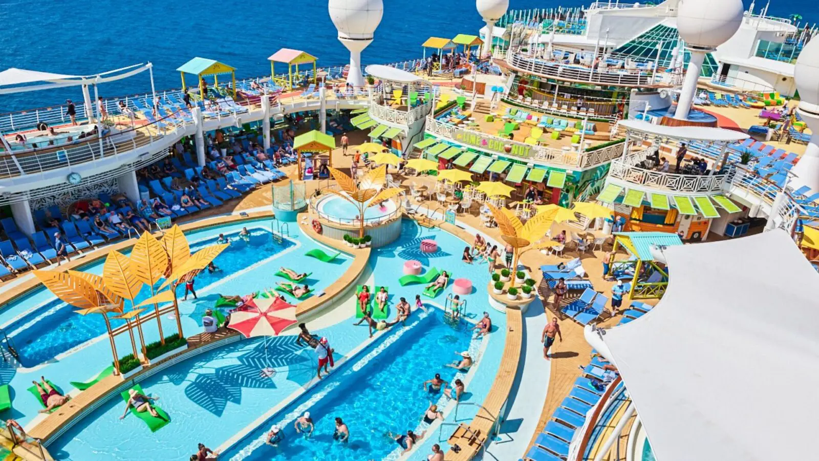 Swimming pool surrounded by many deck chairs on cruise ship