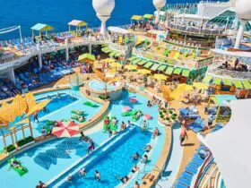Swimming pool surrounded by many deck chairs on cruise ship