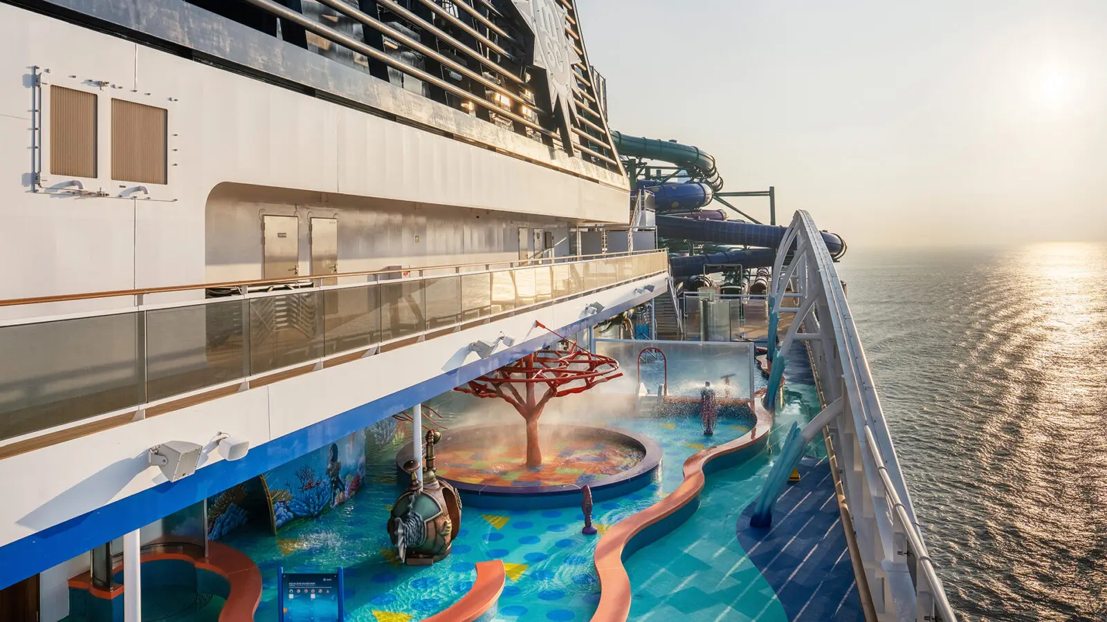 Side of cruise ship with water park at sunset