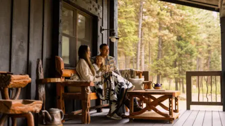 A family shares a moment outside their cabin at Paws Up Montana.