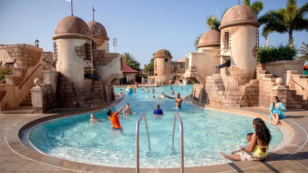 Families swimming in a pool that feels like an old Spanish fort