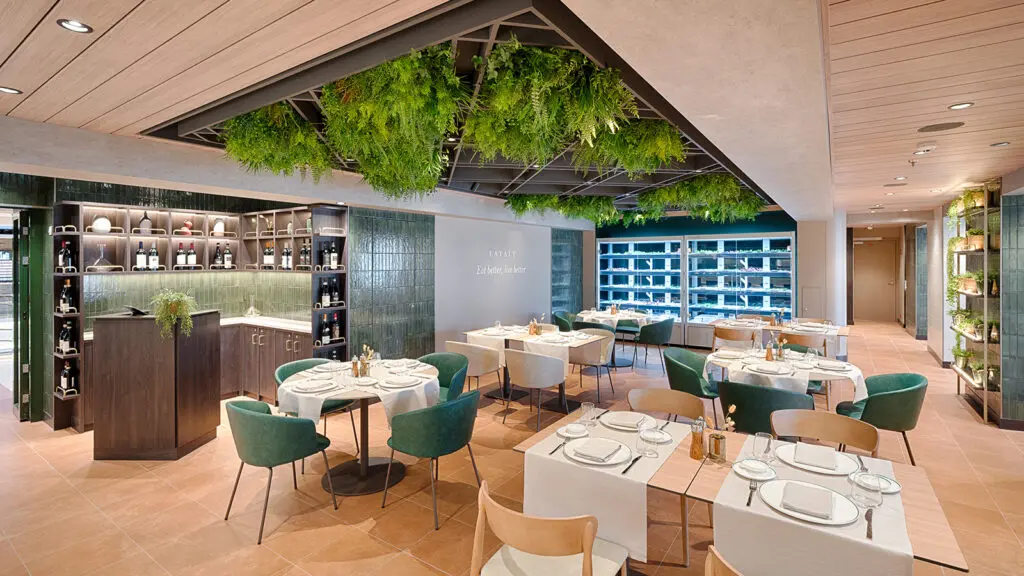 Restaurant with dining tables and greenery hanging from the ceiling