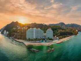 Hotel on mountainous coastline at sunset
