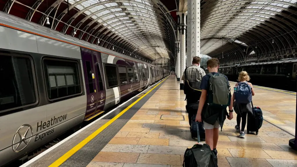 Family walking down the Heathrow Express Platform at Paddington Station in London