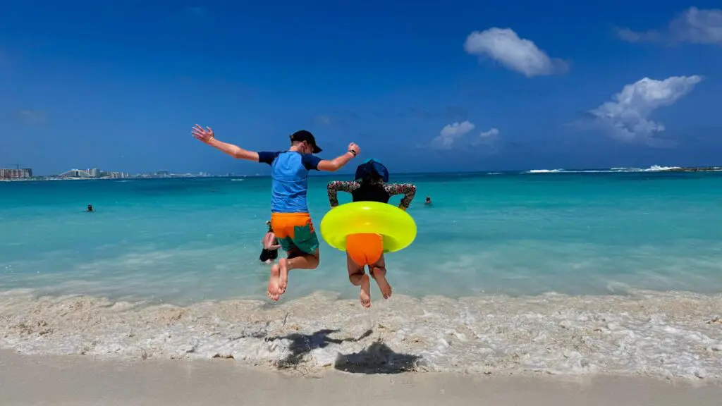 children jumping in the waves on the beach at Club Med Cancun