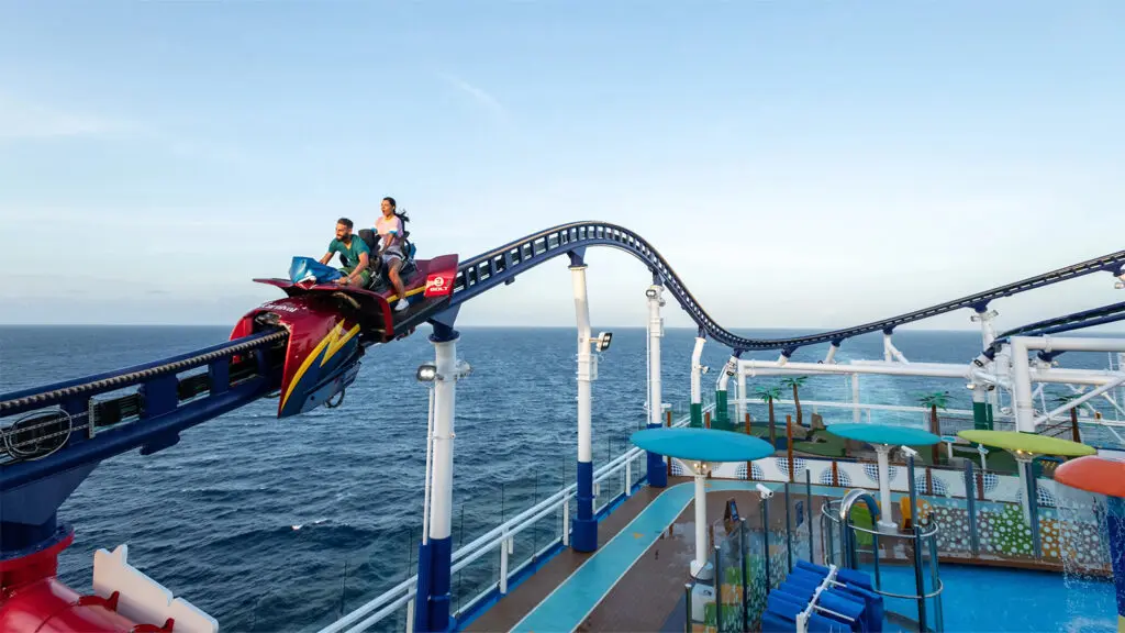 Two people riding on rollercoaster on top of cruise ship