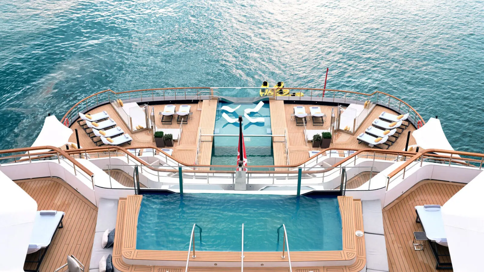 Two swimming pools on decks of cruise ship anchored in ocean