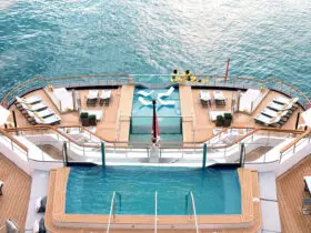Two swimming pools on decks of cruise ship anchored in ocean